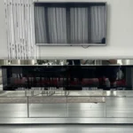 The sleek, mirrored surface of the Silver Mirrored Fireplace TV Stand reflecting its surroundings.