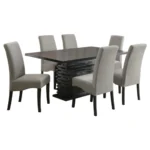 A black dining room set with a large rectangular table and six upholstered grey dining chairs.
