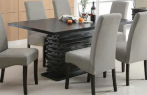 A contemporary black dining table with a unique layered pedestal base in a stylish dining room.