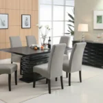 A view of the black dining table styled with chairs and a centerpiece, showing its full design in a modern space.