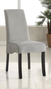 A grey velvet upholstered dining chair with a flared back and black legs.