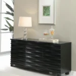Sleek black sideboard with a unique wave-textured front in a modern dining room setting.