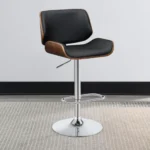 Folsom Upholstered Adjustable Bar Stool in Black Faux Leather with Walnut-Colored Wood Trim and a High-Shine Chrome Base in room.