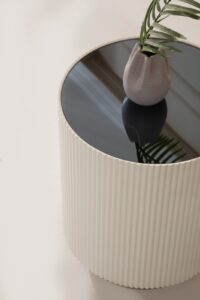 Modern cream and gold end table with sleek design, displayed at a furniture store in Tampa