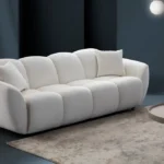 A modern white boucle sofa with a curved arm sofa design in a contemporary living room setting.