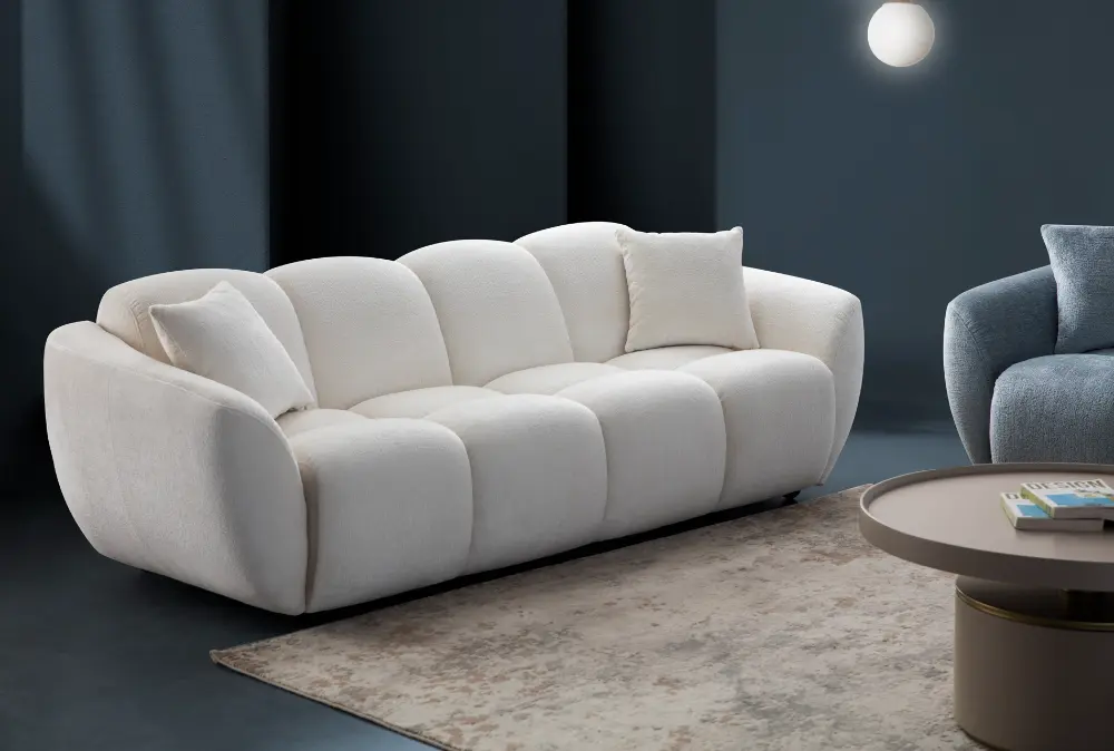 A modern white boucle sofa with a curved arm sofa design in a contemporary living room setting.