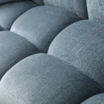 A modern ice gray boucle sofa with a curved sofa design, in an elegant living room setting.