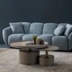 A modern ice gray boucle sofa with a curved sofa design, in an elegant living room setting.