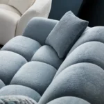 A modern ice gray boucle sofa with a curved sofa design, in an elegant living room setting.