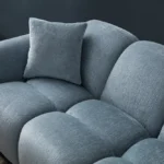 A modern ice gray boucle sofa with a curved sofa design, in an elegant living room setting.