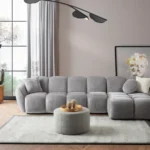 A modern gray boucle sectional sofa with a curved design in a stylish living room.
