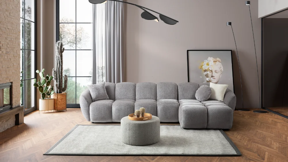 A modern gray boucle sectional sofa with a curved design in a stylish living room.