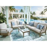 Milas beige outdoor loveseat with blue striped pillows on a blue patterned rug by the pool