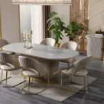 A luxurious beige and gold Cappadocia dining room set, featuring an oval dining table and six velvet chairs.