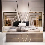 V Luxury Queen Bed with gold mirrored headboard and taupe micro velvet upholstery, shown with matching storage bench and stylish throw pillows.