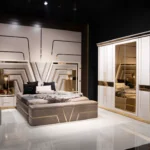 Full view of the V Luxury Bedroom Set, including the King Bed, large mirrored armoire wardrobe, nightstands, and bench in a sophisticated taupe and off-white palette.