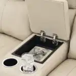 Close-up of the Dahlmoore loveseat console, showing the hidden storage compartment and integrated cup holders. Detail of top grain leather stitching and functionality.