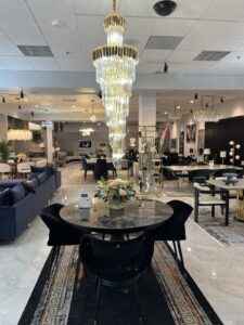 Modern black dining room set with elegant chairs and a high ceiling gold chandelier lighting in a Tampa home.