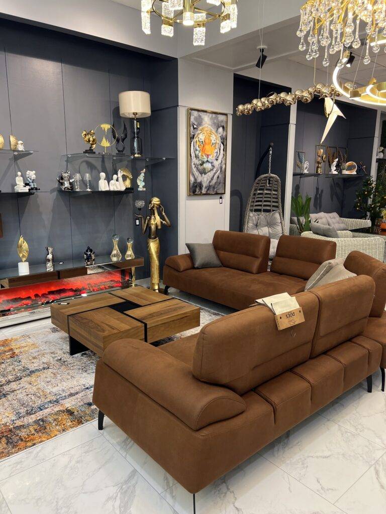 Modern living room set with brown sectional sofa, coffee table, fireplace TV stand, and lighting.