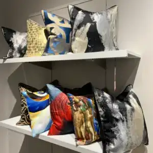 Collection of modern accent pillows with abstract, metallic, zebra, and art-inspired prints, showcasing luxurious fabrics available at the home decor store in Tampa, De'Luxe Home Decor & Furniture.