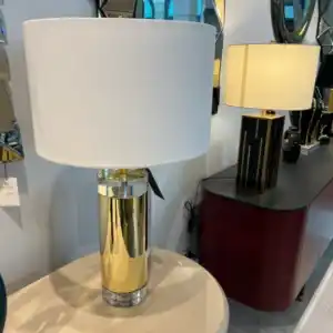 Glamorous modern table lamp with a tall gold cylindrical base, white drum shade, and acrylic details, perfect for luxury home accessories available at the home decor store in Tampa, FL.