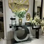 World Console Gray Mirrored Console Table with sculptural circular base, styled with modern decor books and a gold accent mirror.