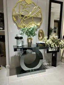World Console Gray Mirrored Console Table with sculptural circular base, styled with modern decor books and a gold accent mirror.