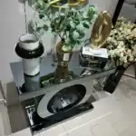 Elevated view of the World Console Gray Mirrored Table with decor, emphasizing the high-gloss surface and artistic base design.