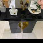 Elegant Italian black and gold console table adorned with decorative items