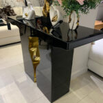Elegant Italian black and gold console table adorned with decorative items
