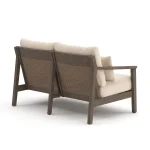 Angled back view of Patara Outdoor loveseat with Beige Cushions showing handwoven wicker panels and eucalyptus frame construction