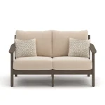 Front view of Patara outdoor loveseat with beige cushions, wood frame, and patterned throw pillows on white background