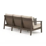 Angled back view of Patara wood outdoor sofa showing handwoven wicker back panels, dark brown acacia wood frame, and sturdy legs
