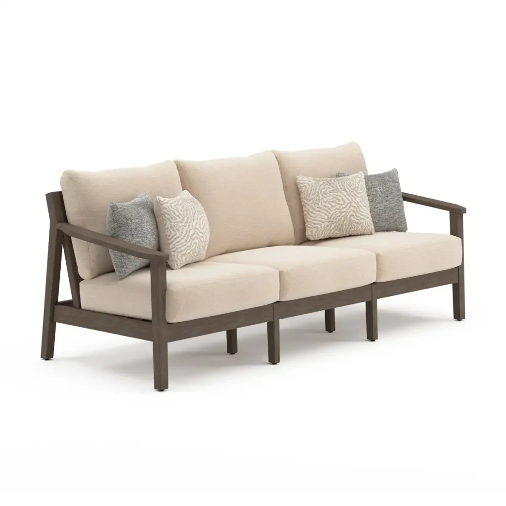 Three-quarter angle view of Patara acacia outdoor sofa showing armrest design, wood frame finish, and plush beige cushion depth