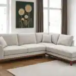 A stylish Mid-Century Modern sectional sofa in light gray chenille fabric, featuring a right chaise and warm walnut tone wood trim, set in a bright living room.