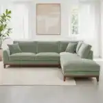 A contemporary Watton Mid-Century Modern sectional sofa in olive green chenille fabric, featuring a right chaise and warm walnut tone wood trim, set in a bright living room.