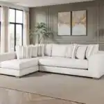 The Alameda Sectional Sofa features natural quartzite upholstery, reversible cushions, and a solid wood frame. Displayed in a transitional living room with neutral décor, this sofa highlights its oversized bench seating and included accent pillows.