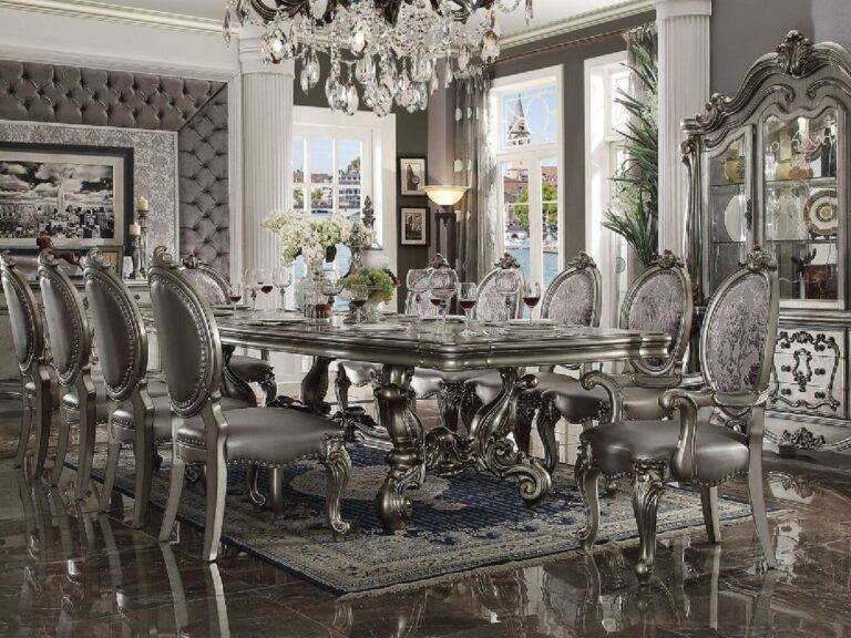 Elegant Acme Dresden Dining Table in Vintage Bone White with ornate carvings, upholstered chairs, and crystal chandelier in a luxurious dining room setting.