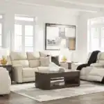 Dahlmoore 3-piece living room set featuring a power sofa, loveseat, and recliner in almond-tone top grain leather, displayed in a modern, light-filled room at the furniture store Tampa.