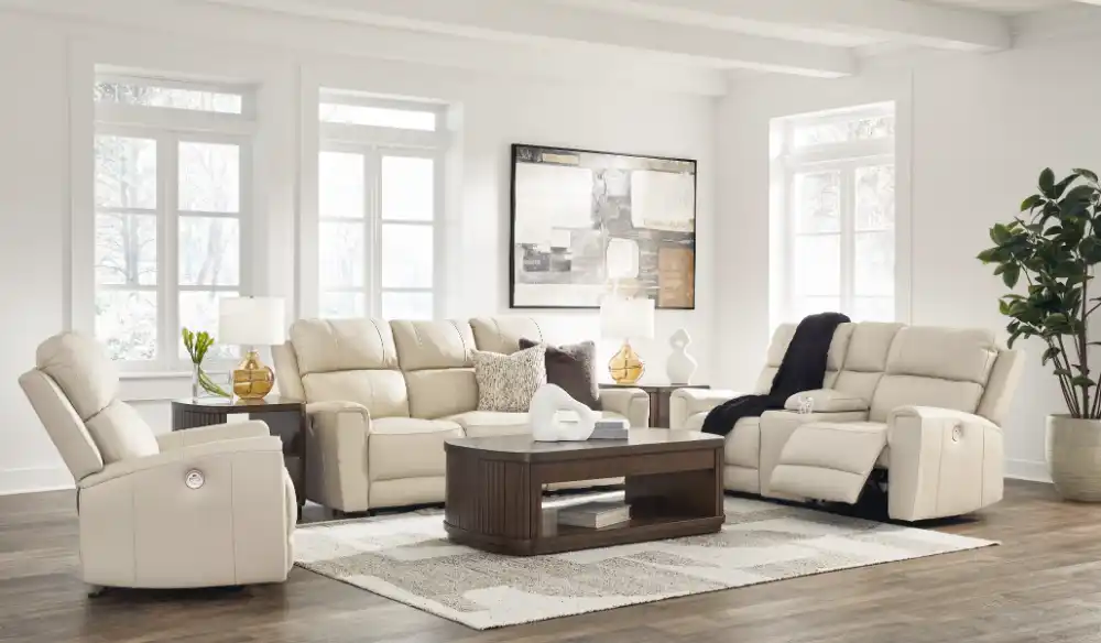 Dahlmoore 3-piece living room set featuring a power sofa, loveseat, and recliner in almond-tone top grain leather, displayed in a modern, light-filled room at the furniture store Tampa.