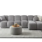 A modern gray boucle sectional sofa with a curved design in a stylish living room.