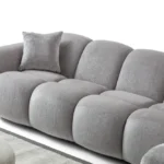A modern gray boucle sectional sofa with a curved design in a stylish living room.