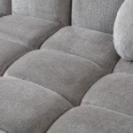 A modern gray boucle sectional sofa with a curved design in a stylish living room.