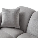 A modern gray boucle sectional sofa with a curved design in a stylish living room.