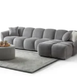 A modern gray boucle sectional sofa with a curved design in a stylish living room.
