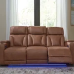 Clean-Slate Caramel Power Reclining Sofa in room setting, fully reclined with blue LED ambient lighting activated and adjustable headrests.