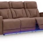Clean-Slate Caramel Power Reclining Sofa showing the footrests extended and the blue LED ambient base lighting from a front angle.