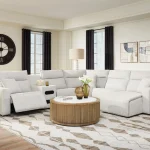 Modmax II light gray reclining sectional sofa set with round wood coffee table and modern lamps in a Tampa home.