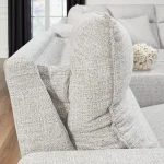 Close up of Next-Gen Nuvella™ high-performance fabric on a light gray reclining sectional sofa.