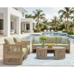 Gumbet green outdoor sofa set arranged on poolside patio with blue leaf-patterned rug, chairs, and oval coffee table